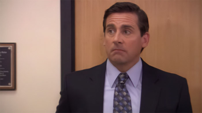 Michael Scott raising eyebrows in an office setting, showcasing qualities of the best boss with memorable quotes.