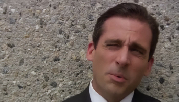 Michael Scott speaking in a suit against a textured wall, showcasing quotes proving hes the best boss ever.