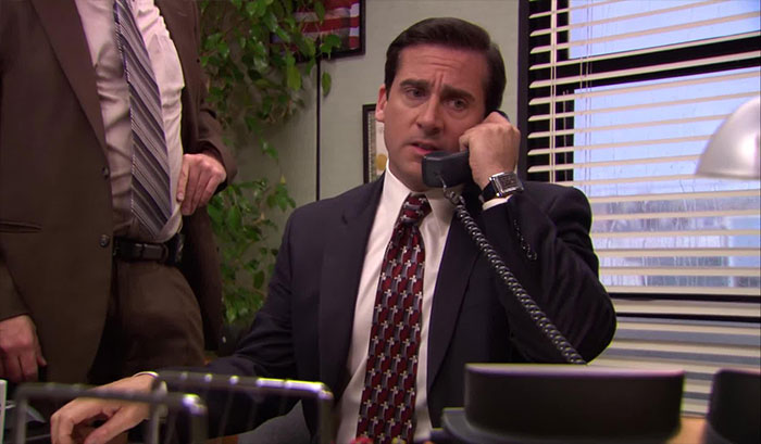 Michael Scott talking on the phone in his office, showcasing quotes proving he’s the best boss ever.