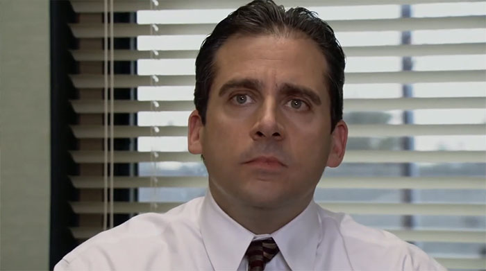 Michael Scott looking thoughtful in an office setting, embodying qualities of the best boss ever in popular culture.