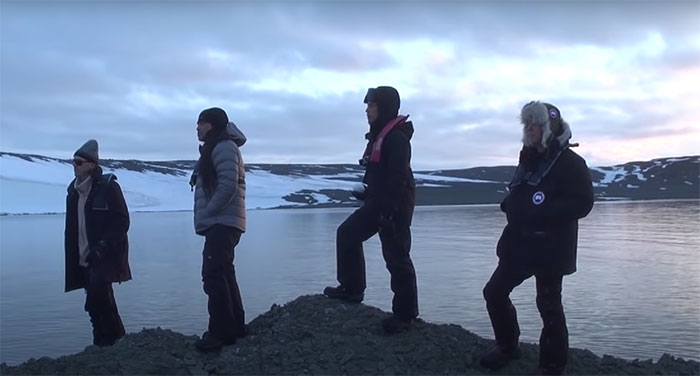 Metallica standing on rocky shore in Antarctica wearing winter gear in a remote icy landscape for music facts content
