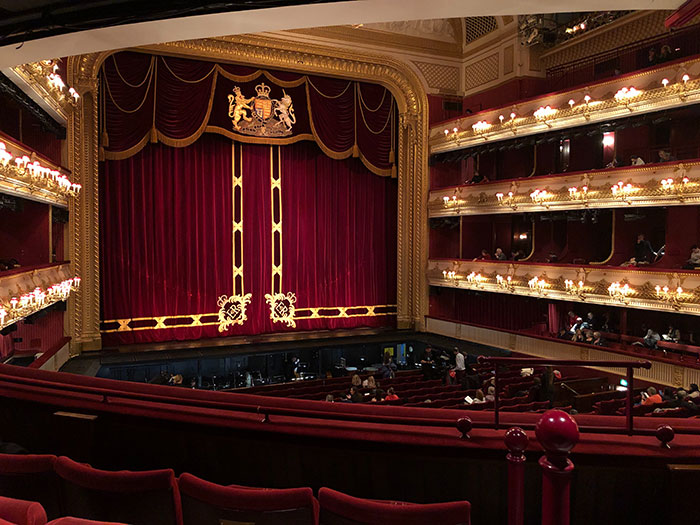 Ornate opera house theatre with red velvet curtains and audience seating, highlighting amazing music facts atmosphere.