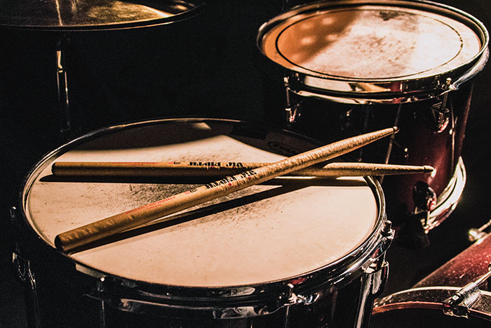 Close-up of drums with sticks resting on the drumhead, highlighting amazing and bizarre music facts about percussion instruments.