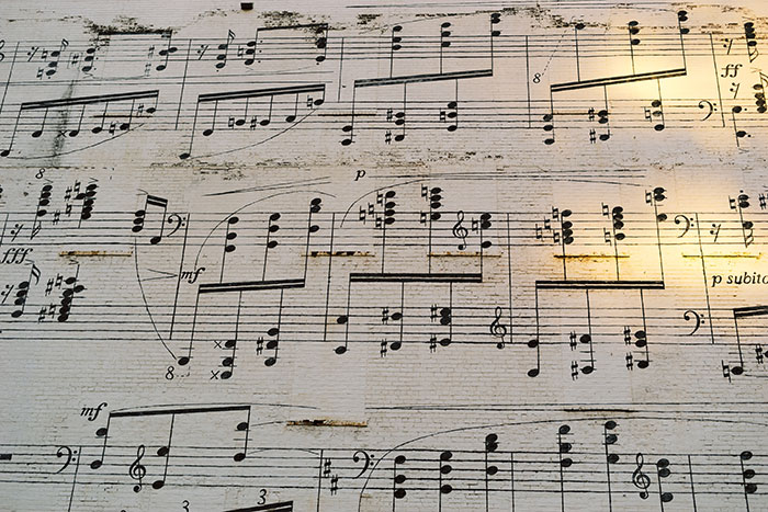 A close-up of an aged music sheet showing detailed musical notes and symbols for soothing ears.