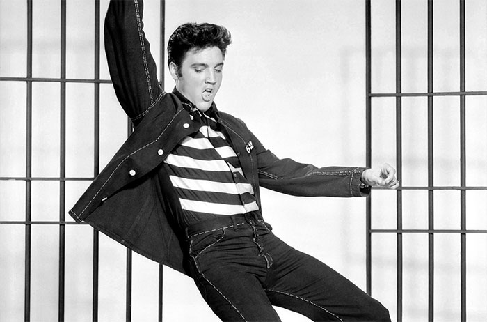 Black and white portrait of Elvis Presley performing with dynamic pose, showcasing iconic music legend in classic style.