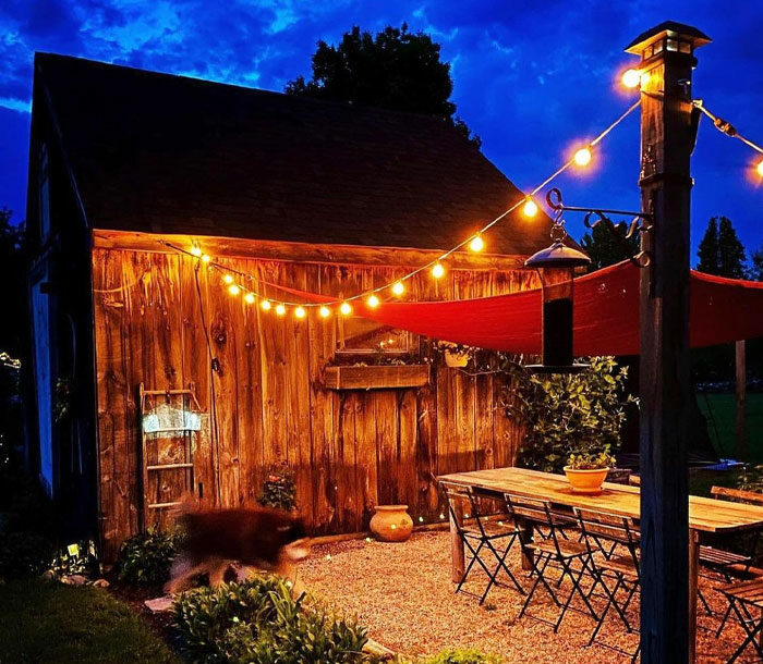 Wooden house with backyard and hanging solar lights Wooden house with backyard and hanging solar lights