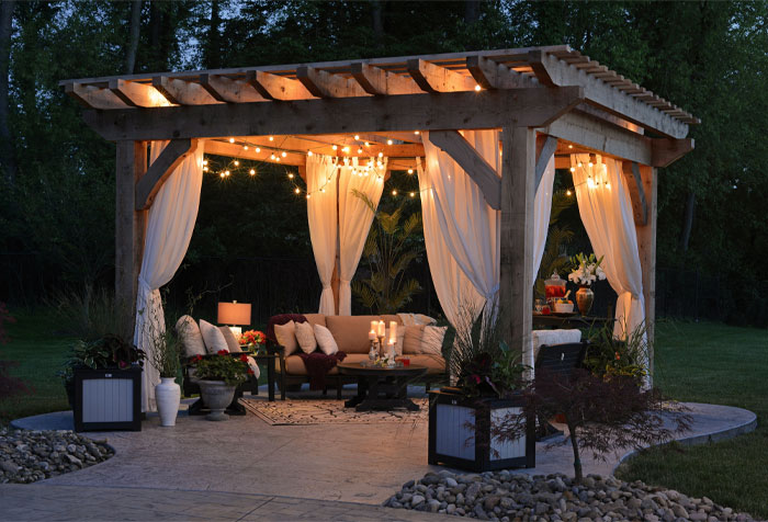 gazebo with curtain and string lights and furniture with white pillows and flowers gazebo with curtain and string lights and furniture with white pillows and flowers