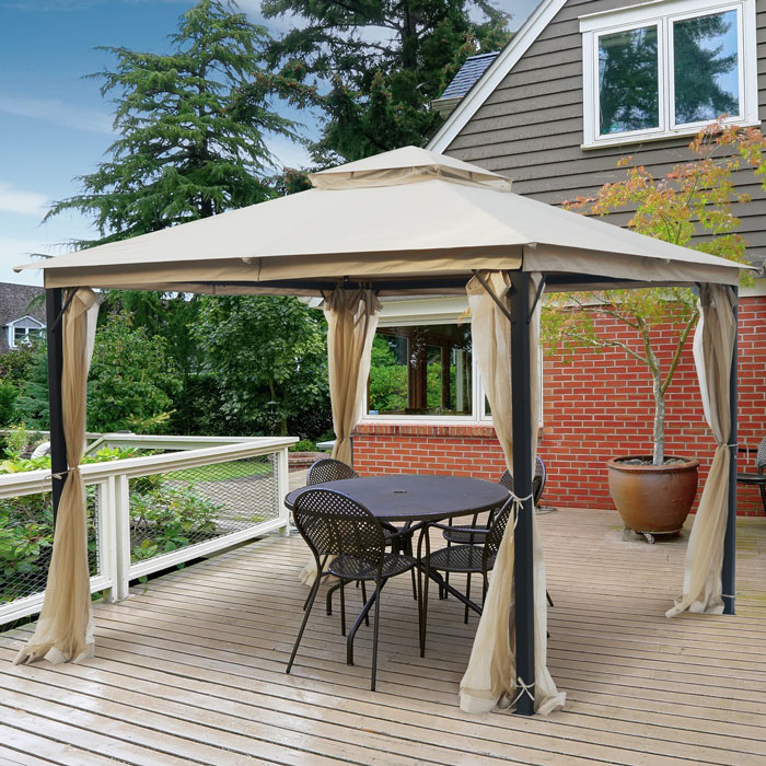 Beige canopy pergola on a wooden patio with black metal chairs creating a stunning backyard outdoor space design.