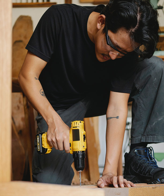 Man using a drill at a woodworking project, illustrating family rejects daughter&rsquo;s fianc&eacute; and revealing his earnings story.
