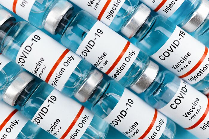 Close-up of multiple COVID-19 vaccine vials arranged together, illustrating human stupidity in vaccine misinformation.