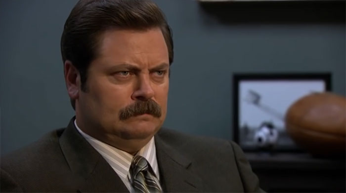 Ron Swanson with an angry expression, wearing a suit and tie, embodying iconic Ron Swanson quotes on life.