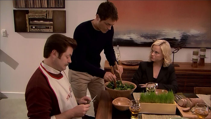 Ron Swanson and Leslie Knope waiting as a waiter prepares a salad in a scene reflecting Ron Swanson quotes on life.