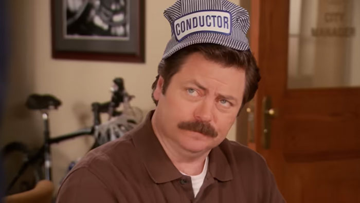 Ron Swanson wearing a blue conductor hat, showcasing a classic expression related to Ron Swanson quotes on life.