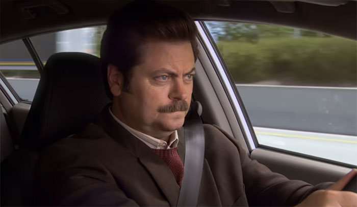 Ron Swanson driving a car with focus and determination, embodying the spirit of Ron Swanson quotes on life and wisdom.