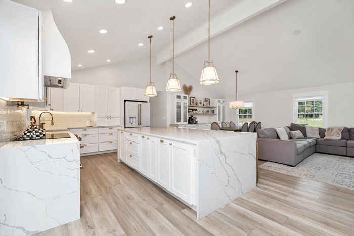 a large kitchen with a center kitchen island and white marble counter tops a large kitchen with a center kitchen island and white marble counter tops