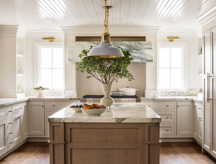 wooden kitchen island with marble countertop and fruits with vase on it wooden kitchen island with marble countertop and fruits with vase on it
