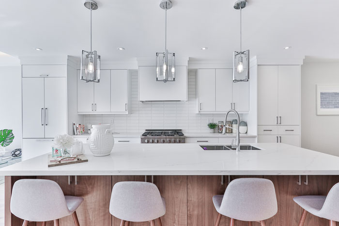 bright kitchen with wooden kitchen island with white countertop and white bar chairs beside bright kitchen with wooden kitchen island with white countertop and white bar chairs beside
