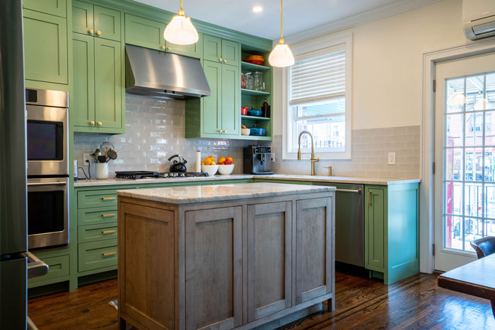 a kitchen with green cabinets and a kitchen island in the center a kitchen with green cabinets and a kitchen island in the center
