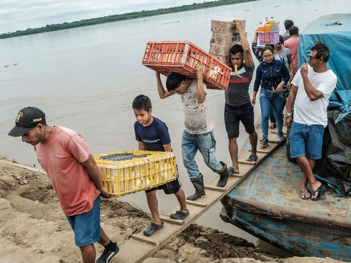 Men offload plastic cages with chickens in them, Maipuco Men offload plastic cages with chickens in them, Maipuco
