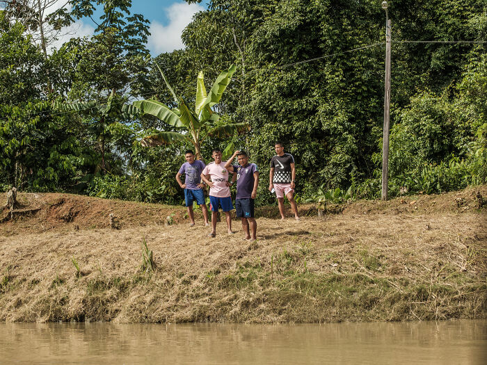 Men observe the passing cargo ship Men observe the passing cargo ship