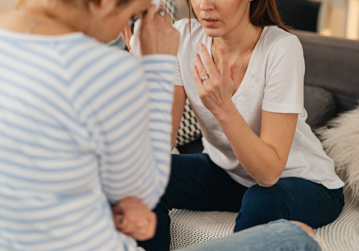 Two women having a serious conversation on a couch, reflecting on relationship struggles and personal life choices. Two women having a serious conversation on a couch, reflecting on relationship struggles and personal life choices.