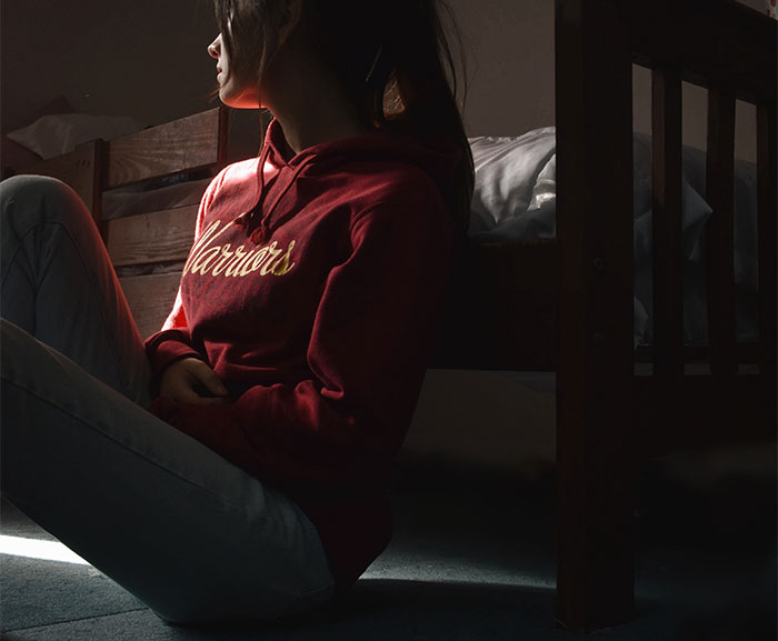 Woman sitting alone on the floor in shadows, representing marriage ending due to refusal to sacrifice life for a baby. Woman sitting alone on the floor in shadows, representing marriage ending due to refusal to sacrifice life for a baby.