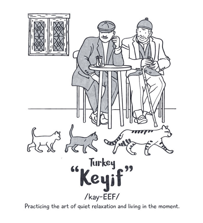 Two men sitting by an outdoor table watching cats passing by