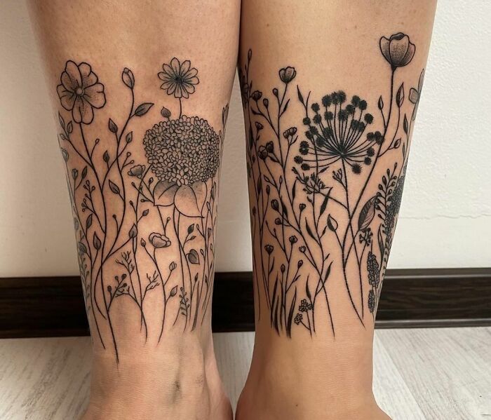Floral ankle tattoo designs on both legs showcasing intricate botanical line art.