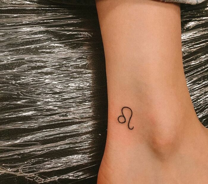Simple ankle tattoo design featuring a Leo zodiac symbol.