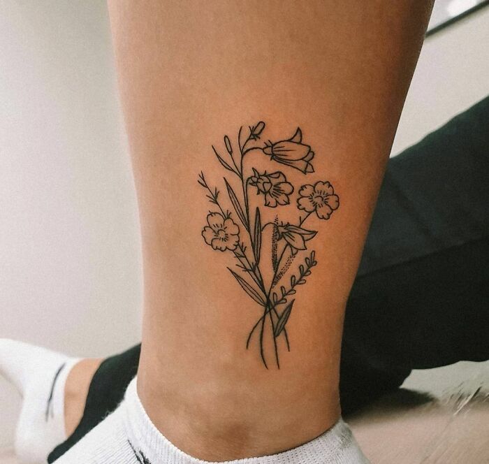 Minimalist floral ankle tattoo design showcasing detailed line art.