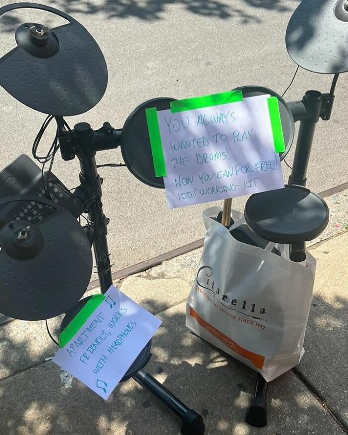 Electronic drum kit with signs offering it for free on the sidewalk, an example of real treasures thrown out in NYC.