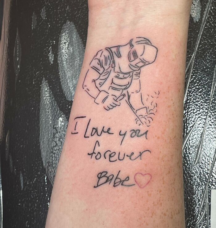 Tattoo design on forearm featuring a welder and the phrase "I love you forever Babe" with a heart, honoring family.