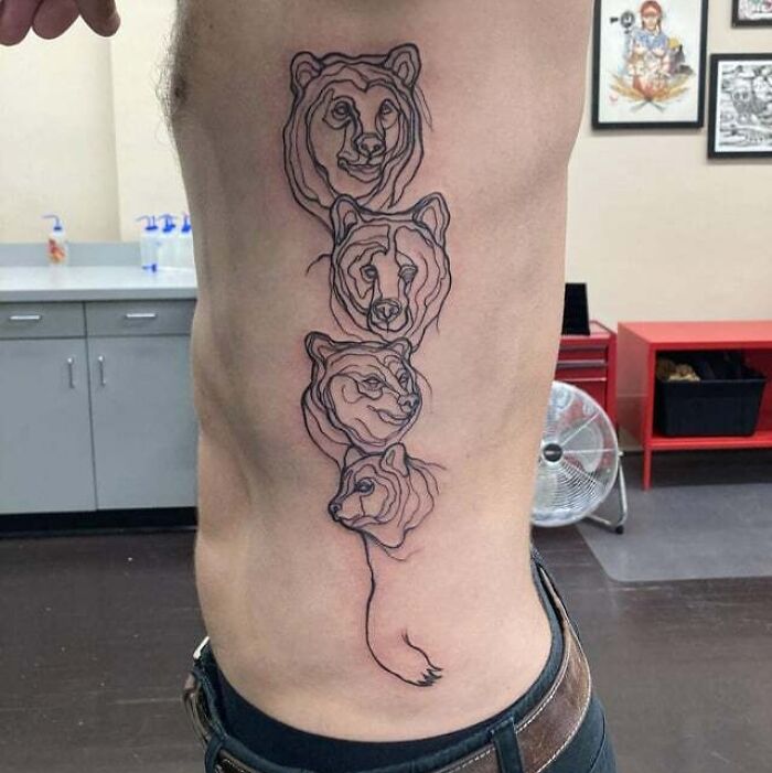 Four animal faces tattooed on side rib symbolize family bonds.