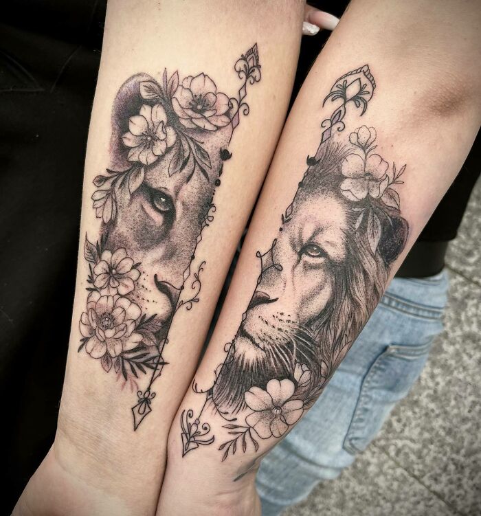 Lion and lioness tattoos on forearms symbolizing unbreakable bonds, adorned with floral designs.