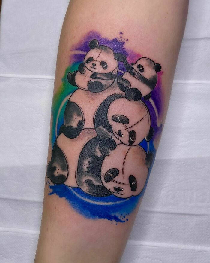 Panda family tattoo symbolizing unbreakable bonds with colorful background on forearm.