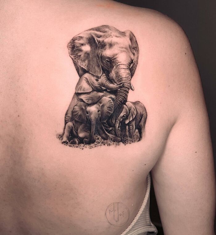 Elephant family tattoo symbolizing unbreakable bonds on a person's back.