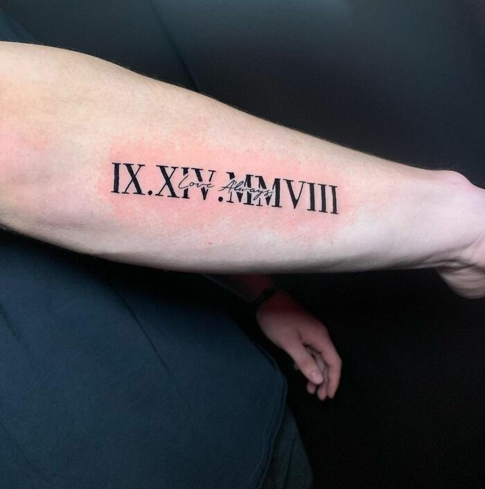 Roman numeral tattoo on forearm with "Love" inscribed, symbolizing a family tribute.