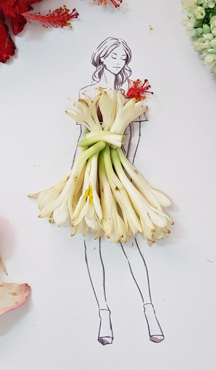 A drawing of a woman dressed in real flower petal gown