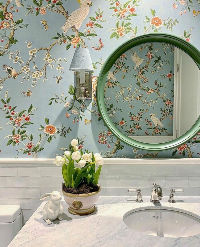 Bathroom with marble sink and blue wallpaper featuring branches and birds, showcasing trendy bathroom wallpaper ideas.