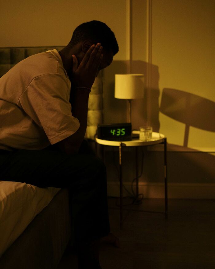 A man sitting in bed early in the morning