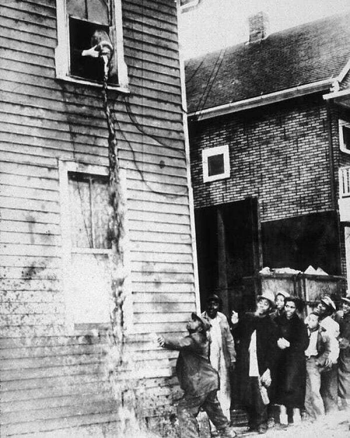 A Bystander Attempts To Catch A Cup Of Moonshine Being Poured Out By Police During The Prohibition Era. 1925