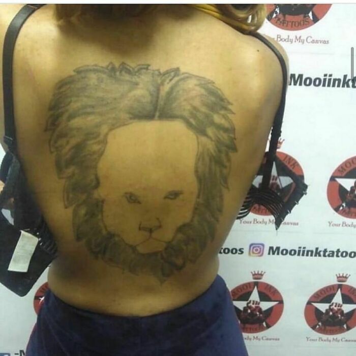 Tattoo fail of a lion design on a person's back, showcasing a humorous lesson in ink.