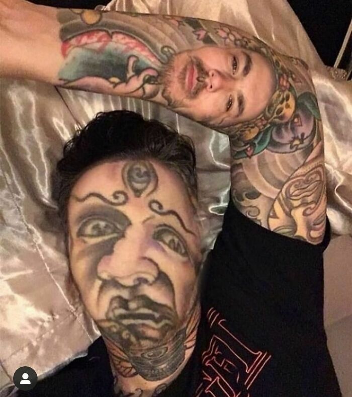 Person with face and arm tattoos lying on a pillow, representing tattoo failures and lessons.