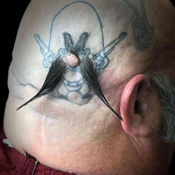 Tattoo with hair integration on a shaved head, showcasing a creative tattoo failure.