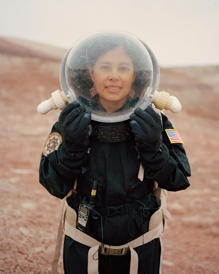 A photograph of a woman with an astronaut helmet on