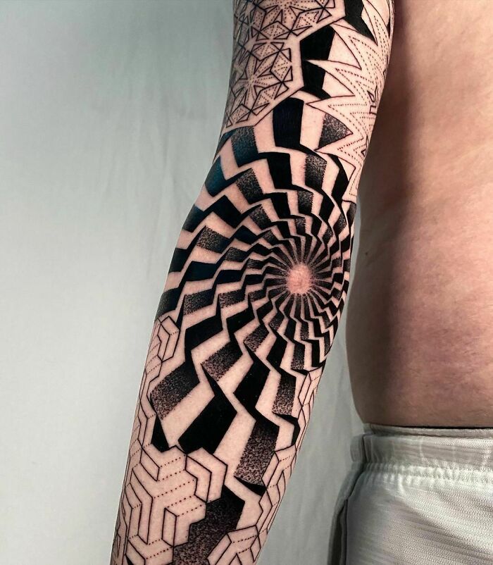 Geometric black and white spiral elbow tattoo design.