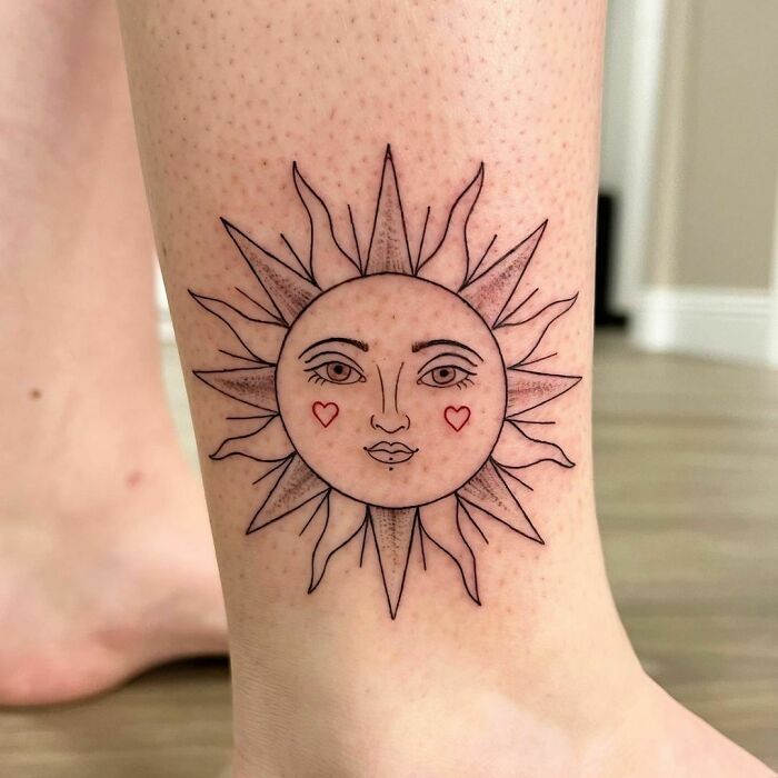Sun face design ankle tattoo with heart details, showcasing tattoo care and inspiration ideas.