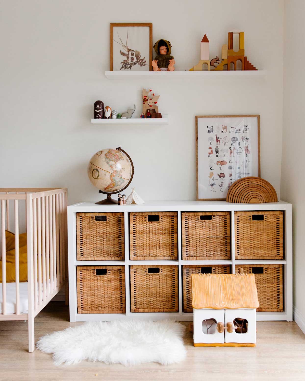 Children's bedroom with wooden furniture, toys, and a globe placed on shelves in the room