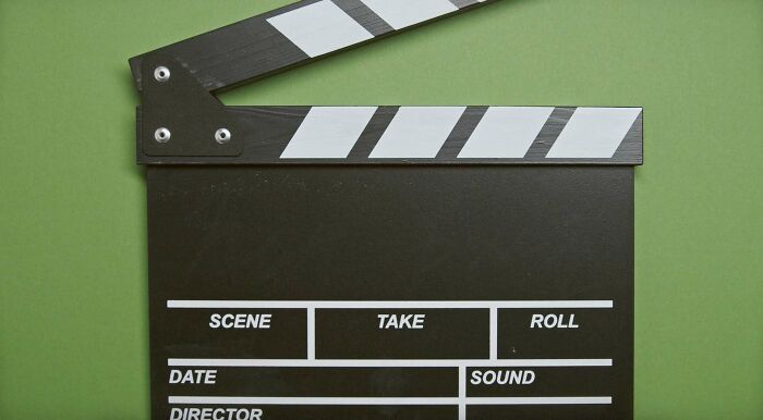 Clapper board on green background symbolizing entertainment and setting the stage for useless facts to impress friends.