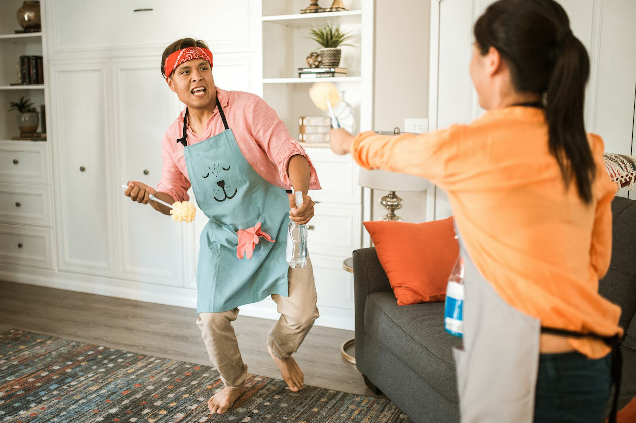A couple playing while cleaning the house